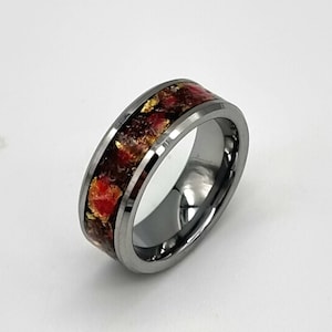 Op de afbeelding: Een ring van wolfraamcarbide met een afgeschuinde rand en een rode en gouden inlay. De inlay is gemaakt van gemalen rood en goud materiaal.