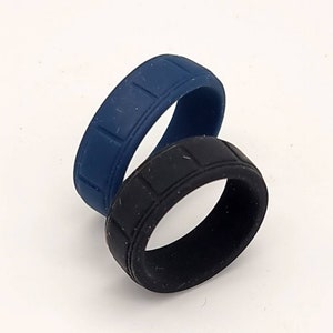 May include: Two silicone rings, one black and one dark blue, with a textured pattern. The rings are stacked on top of each other.