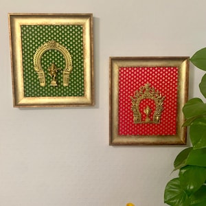 Puede incluir: Dos piezas de decoración de pared enmarcadas con detalles dorados. El marco de la izquierda tiene un fondo verde con un diseño dorado y una estatua dorada. El marco de la derecha tiene un fondo rojo con un diseño dorado y una estatua dorada.