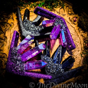 May include: Three crystal clusters, two are purple and one is black. The clusters are made of resin and have a glittery finish. The clusters are arranged in a triangle shape on a wooden surface.