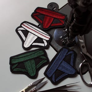 Parche cosido con cadena de suspensorio