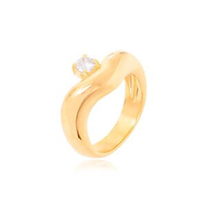 May include: A gold ring with a single clear stone set in the center. The ring is shaped like a wave and has a smooth, polished finish.