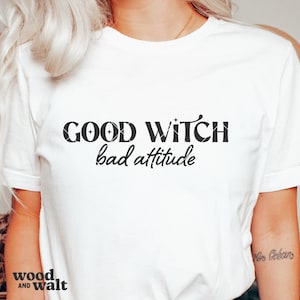 May include: White t-shirt with black text that reads "GOOD WITCH bad attitude".
