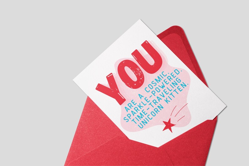 Puede incluir: Una tarjeta blanca con un dise&ntilde;o rosa y rojo. La tarjeta dice "YOU ARE A COSMIC. SPARKLE-POWERED. TIME-TRAVELING UNICORN KITTEN."