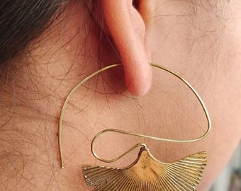 Puede incluir: Aretes de aro dorados con un diseño en forma de abanico. Los aretes están hechos de metal y tienen un aspecto delicado y femenino.