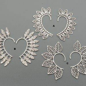 Puede incluir: Tres pares de pendientes de plata con diferentes diseños. El primer par es un diseño delicado y de encaje. El segundo par es un diseño de plumas. El tercer par es un diseño de hojas.