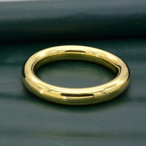 May include: A simple gold band ring with a smooth, polished finish.