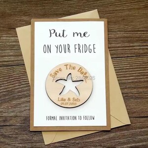 May include: A save-the-date card with a wooden starfish magnet. The card reads "Put me on your fridge" and "Formal invitation to follow." The magnet is engraved with "Save the Date," names, and a date. The card is on a brown envelope.
