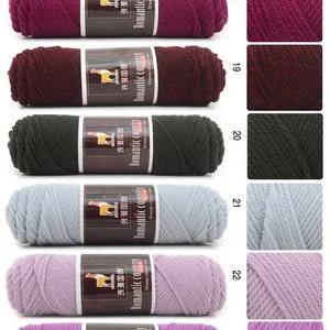 May include: A selection of yarn skeins in various colors, including red, purple, black, gray, and light pink. The yarn is labeled "Romantic Country" and is made of sheep camel hair.