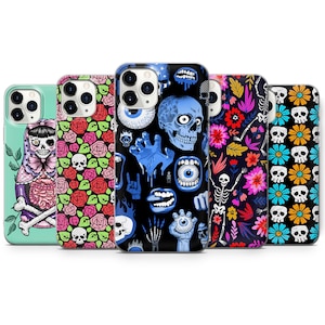 May include: Five different iPhone cases with various colorful and spooky designs. The designs include a skeleton, a skull, a flower pattern, a hand reaching out, and a doll with a skull head.