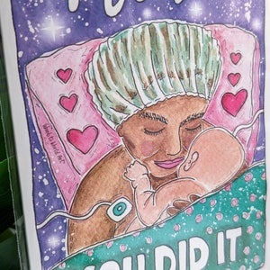 Op de afbeelding: Een aquarelillustratie van een vrouw in een ziekenhuisbed die een pasgeboren baby vasthoudt. De vrouw draagt een operatiekap en een jas. De baby is gewikkeld in een groene deken. De tekst "You Did It" staat in roze letters onderaan de kaart.