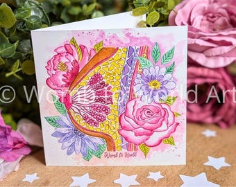 May include: A watercolor illustration of a uterus with flowers surrounding it. The uterus is yellow and pink with a detailed interior. The flowers are pink, purple, and green. The text "Womb to World" is at the bottom of the card.