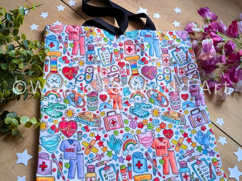 May include: A white tote bag with a colorful print of various medical and nursing-related items, including hearts, stethoscopes, bandages, pills, and rainbows. The text "Nurse" appears multiple times on the bag.