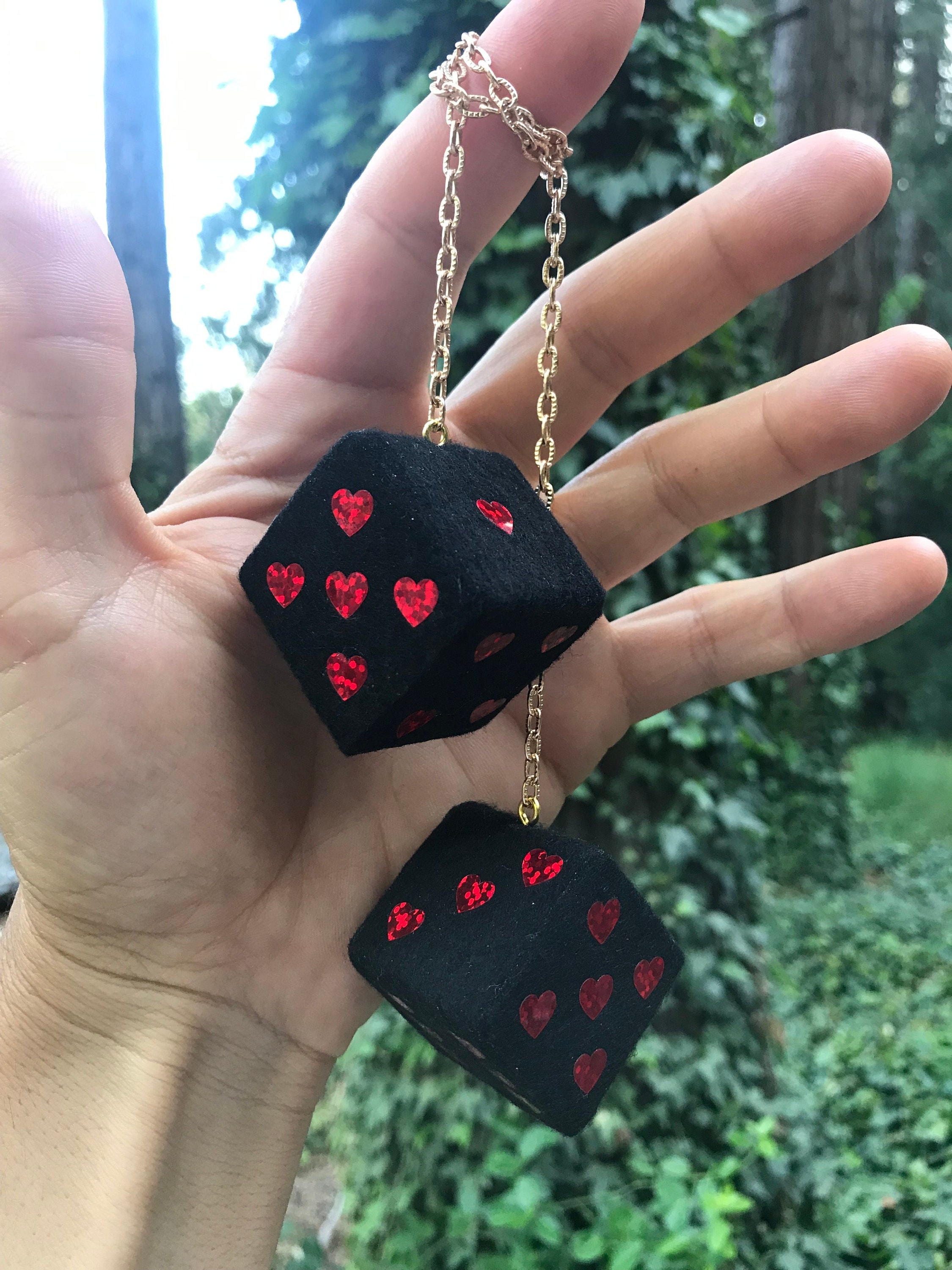 Schwarzer Fuzzy-Würfel mit roten glitzernden Herzen und Kette oder