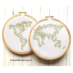 May include: Two embroidery hoops featuring a green world map design. The hoops are made of wood and have a white background.