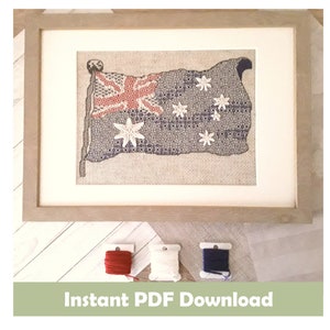 May include: A framed cross-stitch of the Australian flag. The flag is red, white, and blue with a white star in the corner and six white stars in the fly. The frame is a light brown wood.