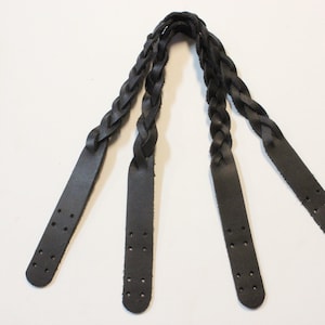 May include: Three black leather straps with holes, braided together at the top.