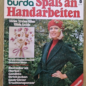 Peut inclure: Une couverture de magazine vintage avec le titre "burda Spaß an Handarbeiten" en rouge. La couverture présente une femme portant un manteau en tweed vert et un béret rouge. Le magazine promeut la couture, le tricot et d'autres travaux manuels.