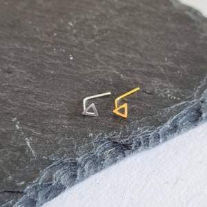 Peut inclure: Deux anneaux de nez avec des motifs triangulaires. L'un est argenté et l'autre est doré.