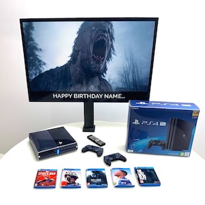 May include: A black PlayStation 4 Pro console with a game controller and a black TV screen displaying a monster with the text "Happy Birthday Name..." on the screen. The console is on a white surface with five video game cases.