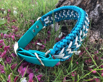Puede incluir: Un collar de perro azul turquesa con una hebilla plateada y un diseño de cuerda trenzada blanca y turquesa.