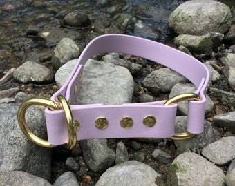 Puede incluir: Un collar de perro de cuero lavanda con herrajes dorados y cuatro remaches de latón martillados.