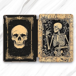 May include: A black and gold iPad case with a skull and skeleton design. The case has a vintage look with a floral pattern and musical notes.
