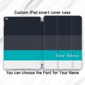 Puede incluir: Una funda inteligente para iPad de color blanco con interior negro y una franja azul turquesa. La funda tiene un espacio para un nombre personalizado, "Your Name", en texto blanco. Puedes elegir la fuente para tu nombre.