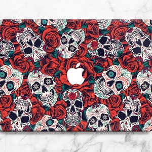 May include: A laptop skin with a colorful pattern of red roses and sugar skulls. The design is a traditional Mexican Day of the Dead theme.