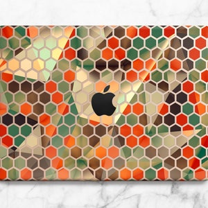 Könnte beinhalten: Eine Laptop-Haut mit einem geometrischen Muster aus orangefarbenen, grünen und braunen Sechsecken. Die Haut hat einen dezenten Glanz und ein modernes Design.