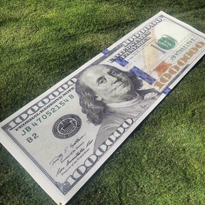 May include: A $1,000,000 US bill with a portrait of Benjamin Franklin. The bill has a blue and gold design with the text "FEDERAL RESERVE NOTE" and "JB 47052154 B" printed on it.