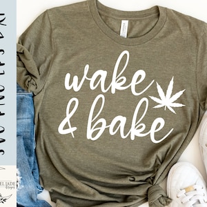 Peut inclure: Un t-shirt vert avec le texte "wake & bake" en lettres blanches et un graphique de feuille de marijuana blanche.