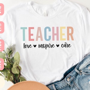 Może przedstawiać: Biała koszulka z napisem "TEACHER" w pastelowych kolorach. Poniżej słowa "love", "inspire" i "care" oddzielone czarnymi sercami. Koszulka jest zestawiona z dżinsowymi szortami i kapeluszem w neutralnym kolorze.