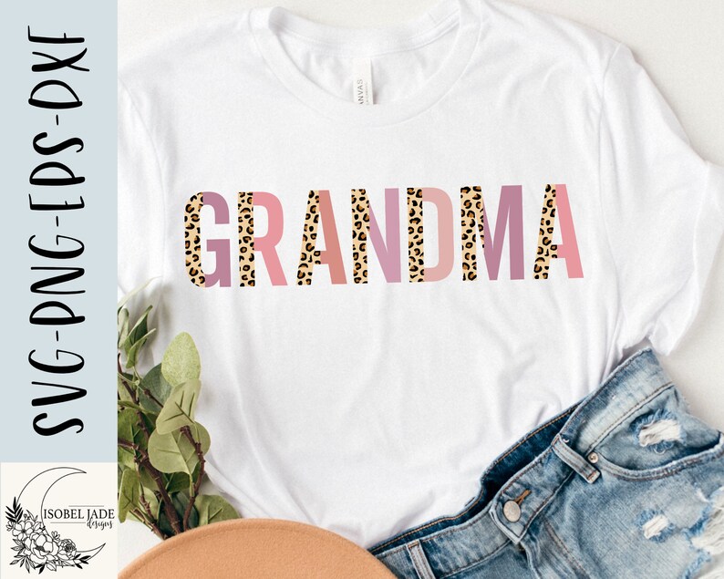 May include: A white t-shirt with the word "GRANDMA" printed in pink, peach, and brown leopard print letters.