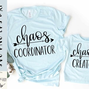 May include: Two light blue t-shirts with black text. The larger shirt says "chaos coordinator" with an arrow pointing to the right. The smaller shirt says "chaos creator" with an arrow pointing to the right.