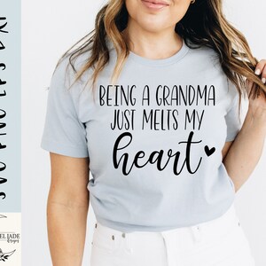 May include: A light blue t-shirt with the text "Being a grandma just melts my heart" in black lettering with a small heart symbol.