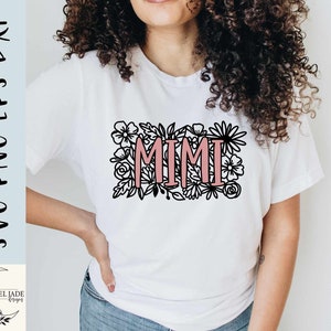 May include: A white t-shirt with a black floral design and the word "MIMI" in pink lettering.