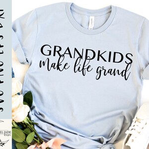 May include: A light blue t-shirt with the text "Grandkids make life grand" printed in black.