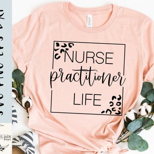 May include: A pink t-shirt with black text that reads "NURSE practitioner LIFE" inside a black square frame. The frame is decorated with black leopard print spots.