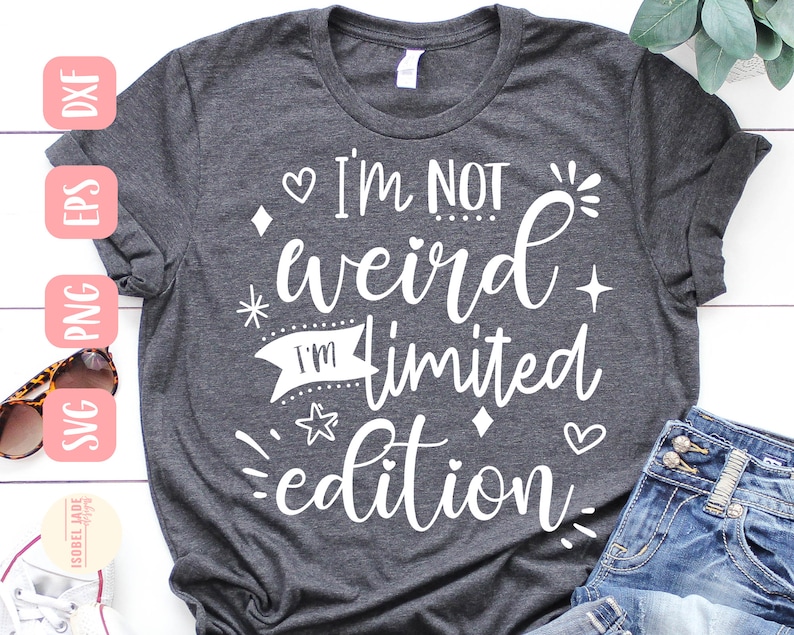 May include: A gray t-shirt with the text "I'm not weird I'm limited edition" in white. The text is surrounded by small hearts, stars, and diamonds.