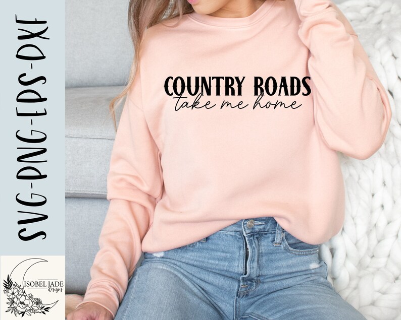 May include: A pink sweatshirt with the text "COUNTRY ROADS take me home" in black lettering.