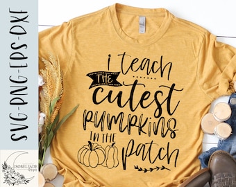 May include: A yellow t-shirt with black text that reads "I teach the cutest pumpkins in the patch". The text is in a handwritten font. There are two pumpkins in the bottom center of the shirt.