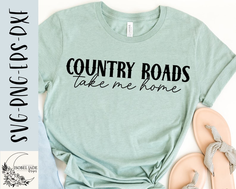 May include: A light blue t-shirt with the text "COUNTRY ROADS take me home" in black lettering. The text has a distressed look.