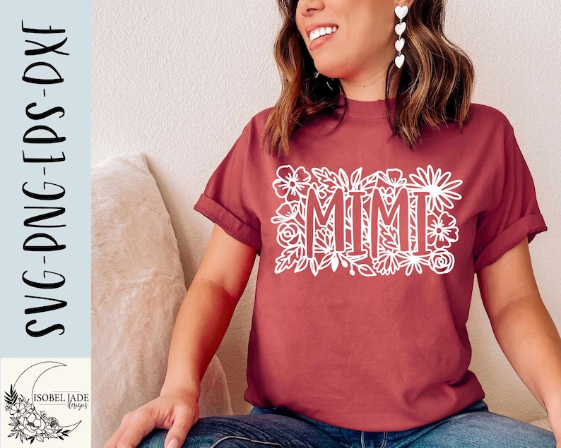 May include: A maroon t-shirt with a white floral design and the word "MIMI" in the center.