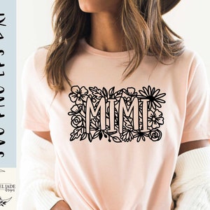 May include: A pink t-shirt with a black floral design and the word "MIMI" in the center.