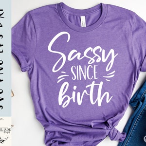May include: Purple t-shirt with white text that reads "Sassy Since Birth".