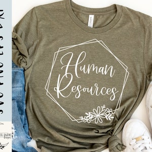May include: A green t-shirt with a white graphic design that says "Human Resources" in a geometric frame with floral accents.