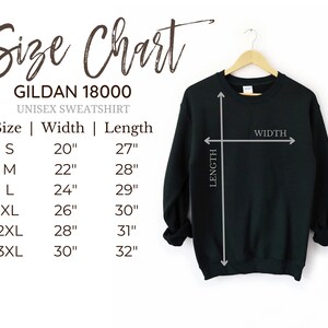 Puede incluir: Una sudadera unisex negra Gildan 18000 colgada de una percha de madera. La imagen incluye una tabla de tallas con medidas en cm: S (51cm ancho, 69cm largo), M (56cm ancho, 71cm largo), L (61cm ancho, 74cm largo), XL (66cm ancho, 76cm largo), 2XL (71cm ancho, 79cm largo) y 3XL (76cm ancho, 81cm largo).