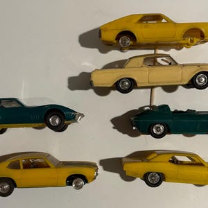 May include: A set of three ceramic mugs with a speckled, matte finish. The mugs are in shades of cream, light gray, and dark gray. Each mug has a simple, minimalist design, perfect for coffee or tea.