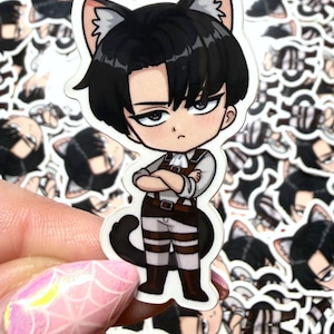 May include: A sticker featuring a chibi-style anime character with black hair and cat ears. The character is wearing a brown and white uniform with a belt and boots. The sticker has a black tail and is surrounded by similar stickers.